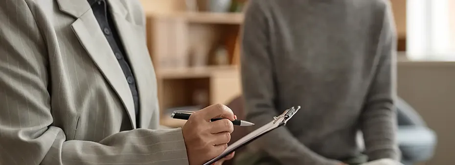 female-therapist-holding-clipboard-taking-notes