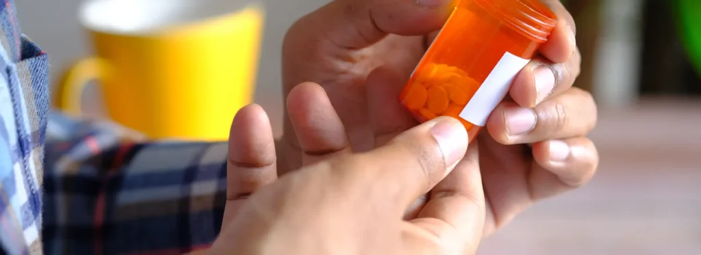 rear-view-young-man-hand-hold-medical-pill-container